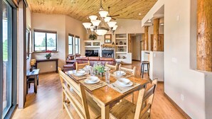 Un coin repas avec une table en bois dressée pour quatre personnes, entourée de chaises en bois.
