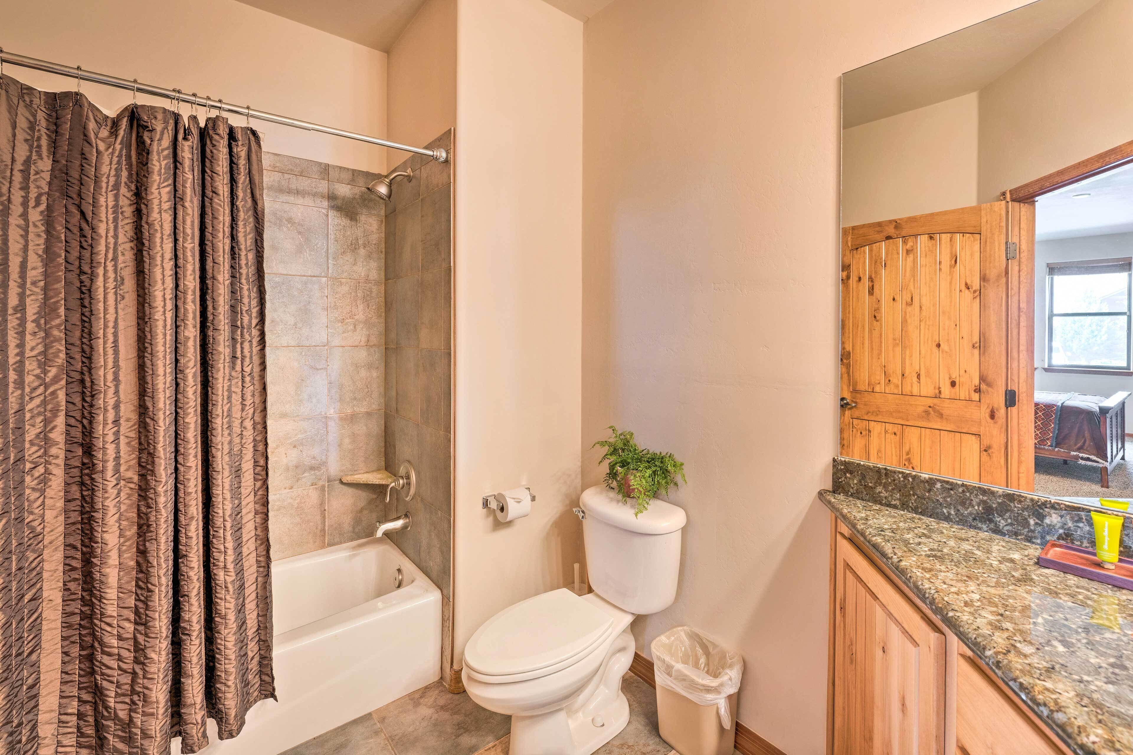 Une salle de bain avec une douche, des toilettes et un meuble en bois.