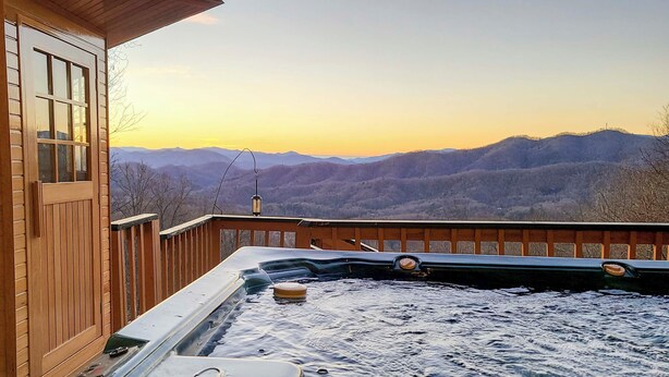 Ein Whirlpool mit Holzterrasse und Bergblick.