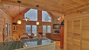Ein Holzblockhaus mit Küche, Essbereich und Wohnzimmer.