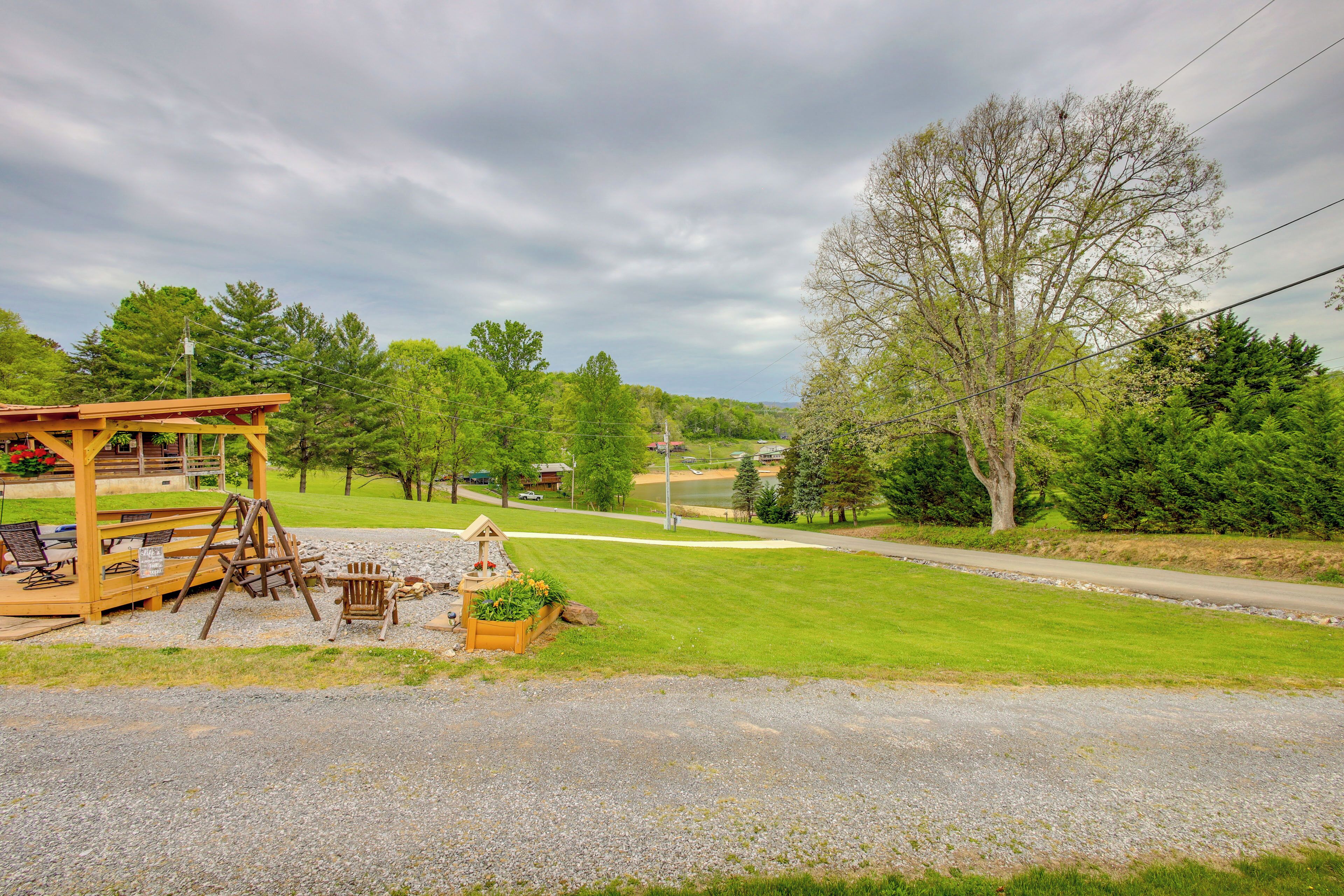 A gazebo with outdoor seating, a baseball field, and a large tree in the background.