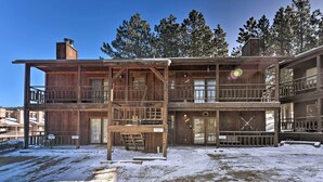 A wooden two-story building with a balcony and a staircase. - Cozy Angel Fire Condo < Half Mi to Resort! (Angel Fire)