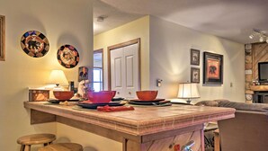 A kitchen with a wooden island, stools, and a fire extinguisher. - Cozy Angel Fire Condo < Half Mi to Resort! (Angel Fire)