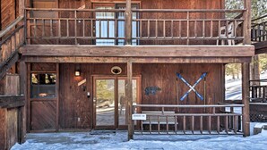 A wooden building with a double staircase, a wooden door, and a bench. - Cozy Angel Fire Condo < Half Mi to Resort! (Angel Fire)