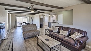 A spacious living room with a brown leather sofa, patterned armchair, and a wooden coffee table. A ceiling fan and recessed lighting are visible. - Near Marina: Home w/ Pool & Views in Lake Havasu! (Lake Havasu City)