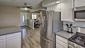 A modern kitchen with stainless steel appliances, white cabinetry, and a wood floor. - Near Marina: Home w/ Pool & Views in Lake Havasu! (Lake Havasu City)
