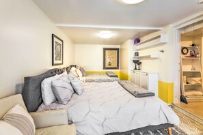 A bedroom with a bed, bedside tables, a wardrobe, and a small seating area. - Cincinnati Basement Unit ~ 10 Mi to Downtown! (Cincinnati)