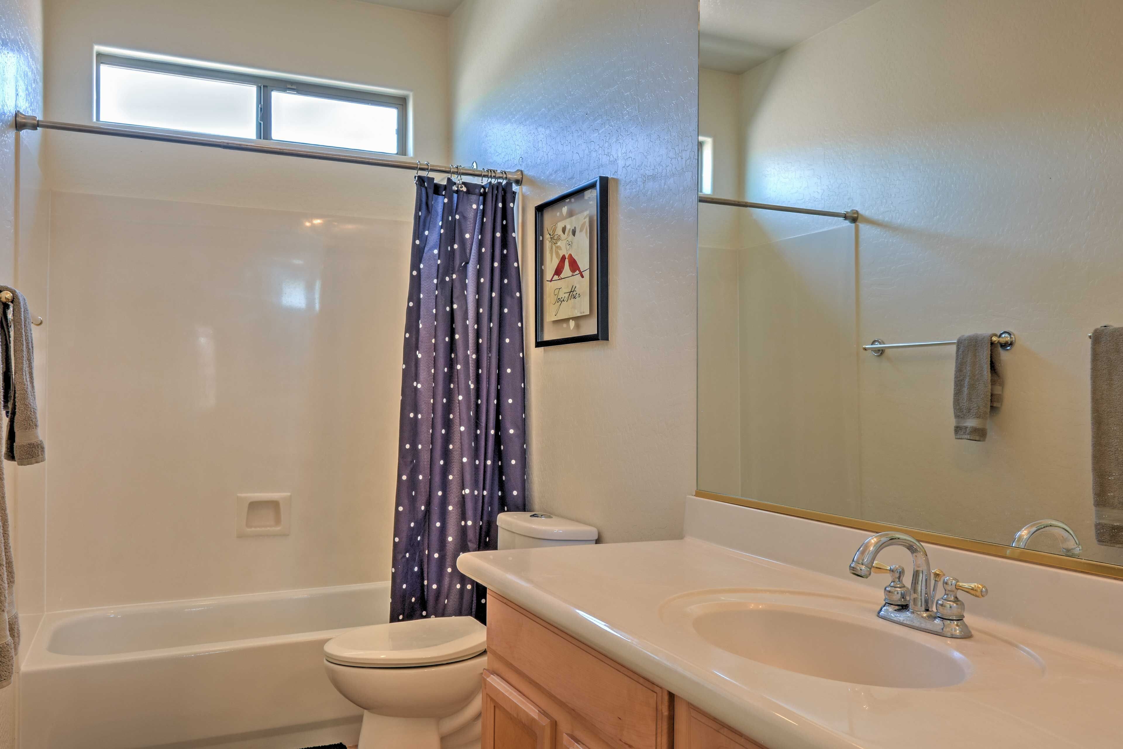 A bathroom with a bathtub, toilet, and sink.