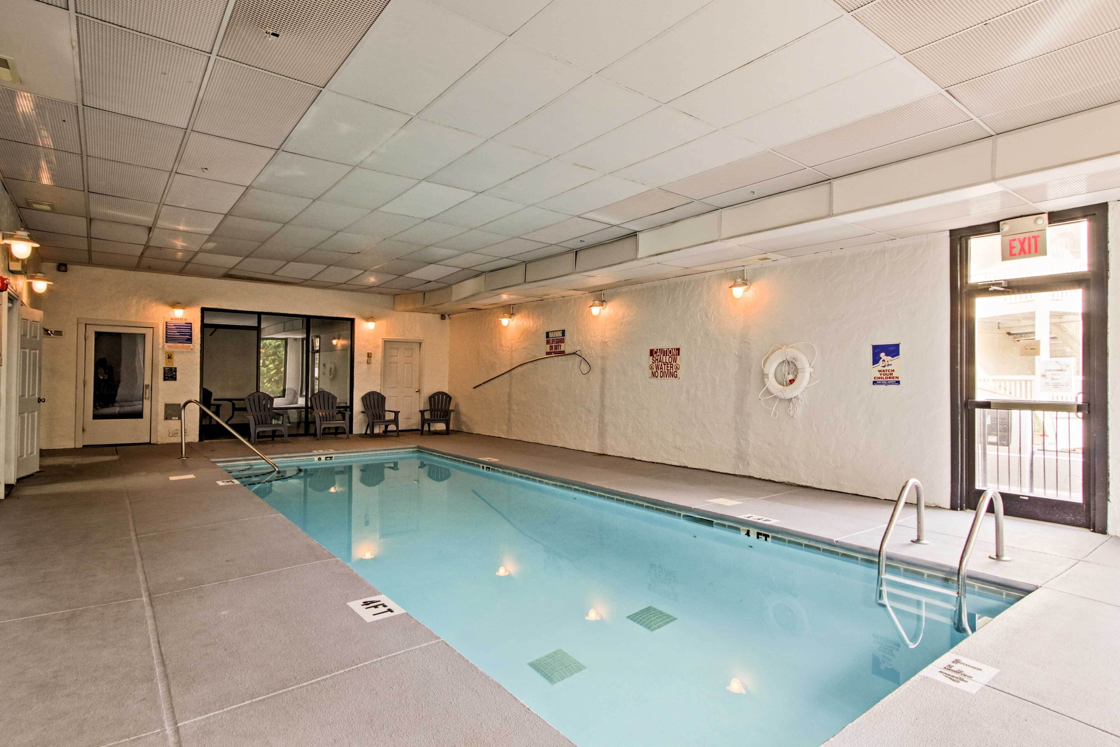 An indoor swimming pool with clear lane markings, a lifeguard chair, and a sign indicating no diving.