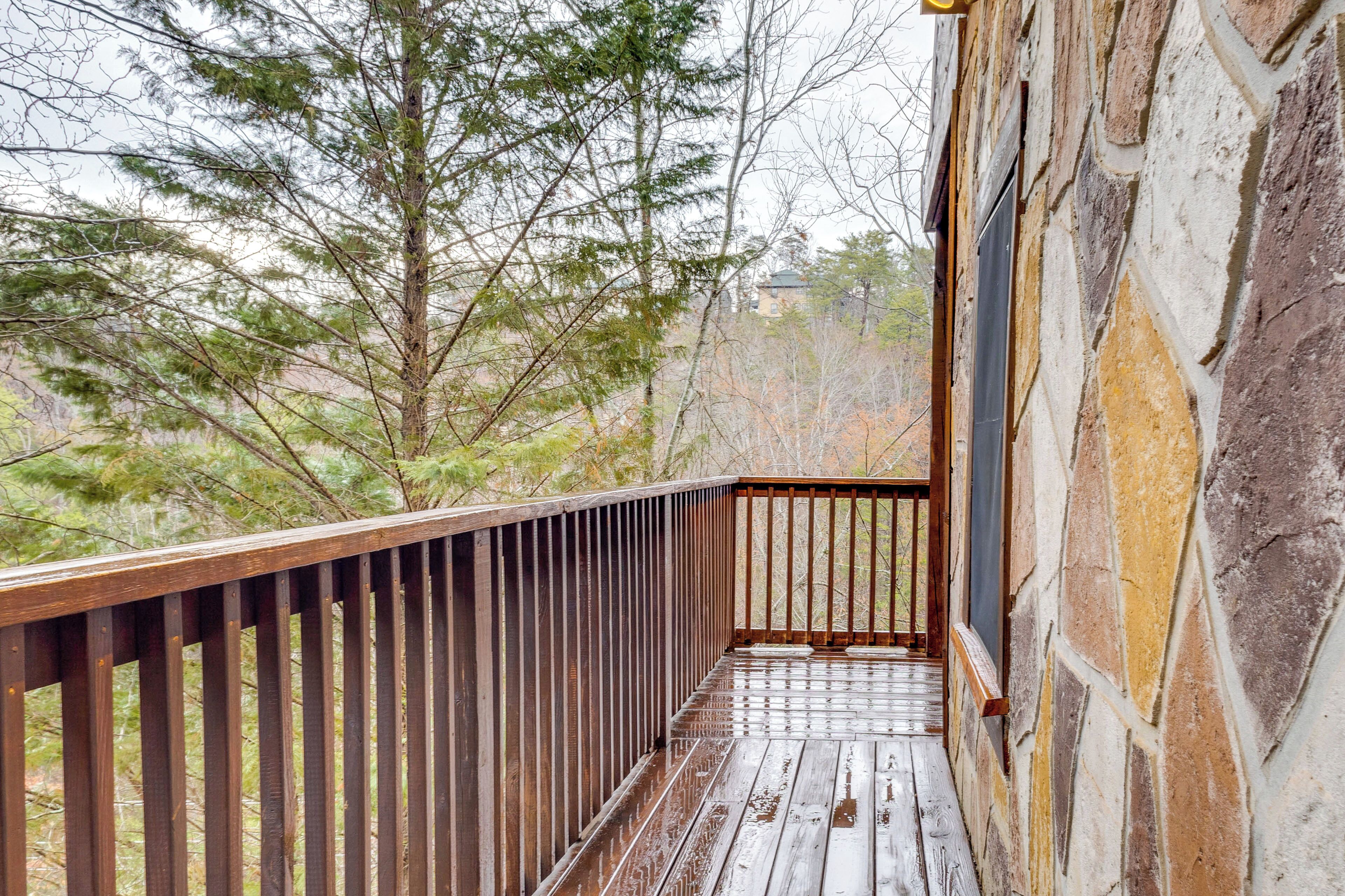 Une terrasse en bois avec un mur de pierre d’un côté.