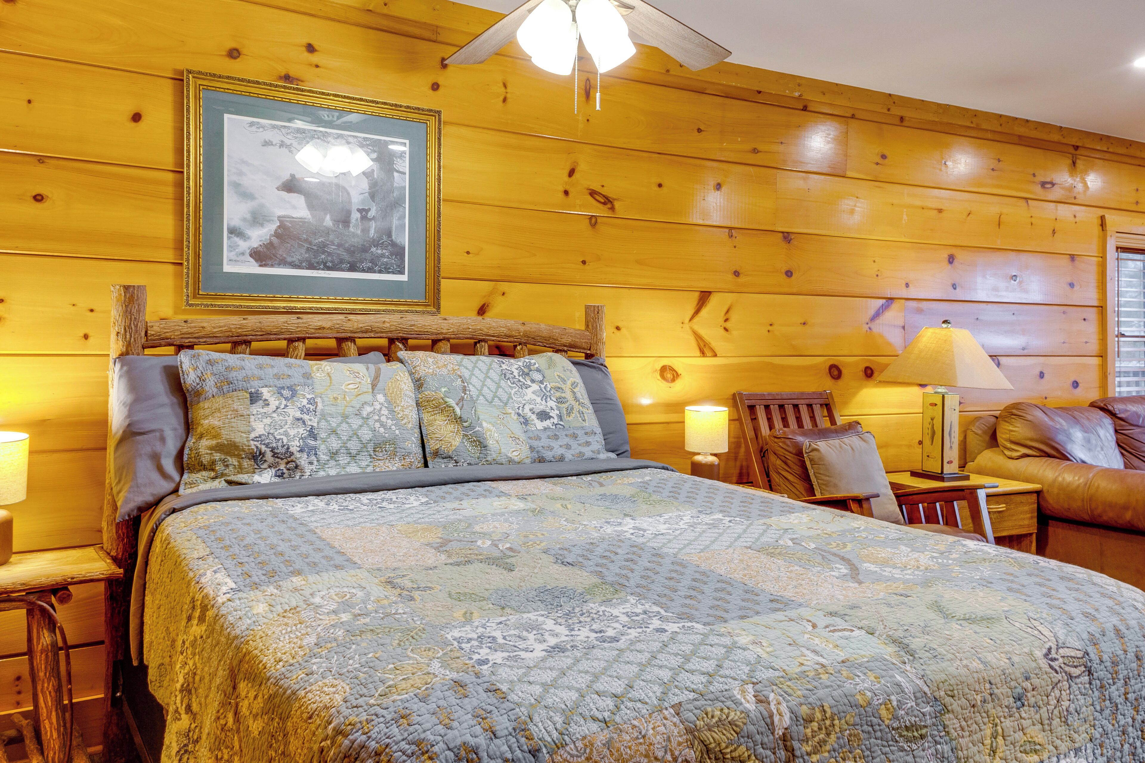 Una habitación con paneles de madera, una cama, una silla, una mesa y una lámpara.