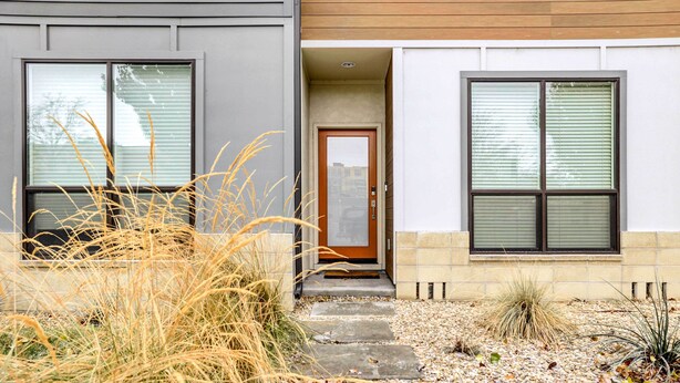 A modern house with a front door, two windows, and a gravel pathway leading to the entrance. - Beautiful Townhome - Steps to Downtown Boise! (Boise)
