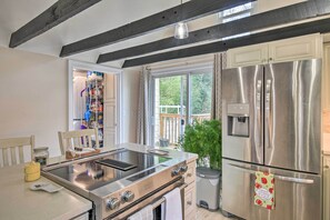 A modern kitchen with a built-in stove, stainless steel appliances, and a view to the outdoors. - Charming Cape Charles Vacation Rental Home! (Cheriton)