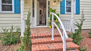 A house with a brick porch, white columns, and blue shutters. - Charming Cape Charles Vacation Rental Home! (Cheriton)