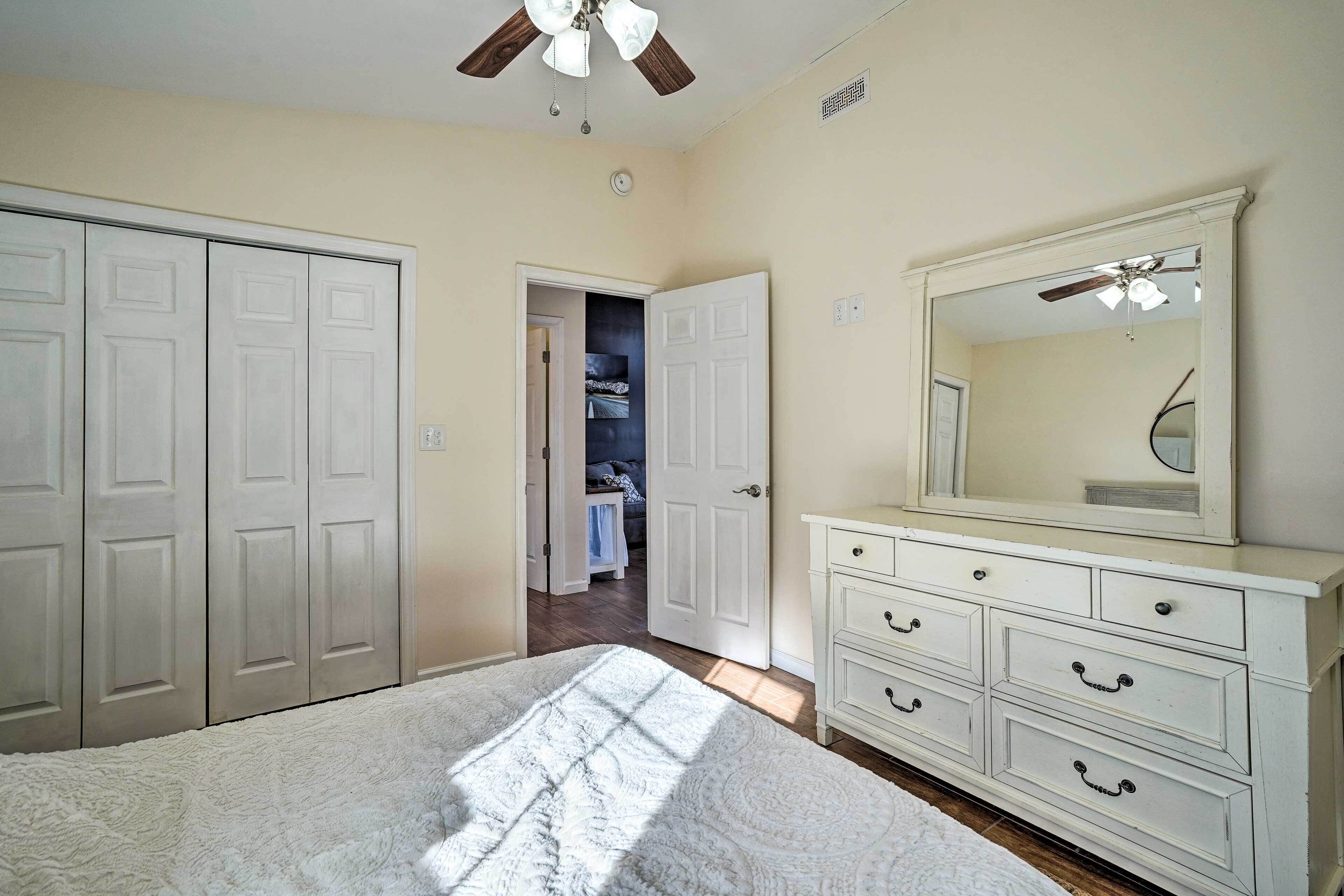 Une chambre à coucher avec un lit, une commode, un miroir et un placard.