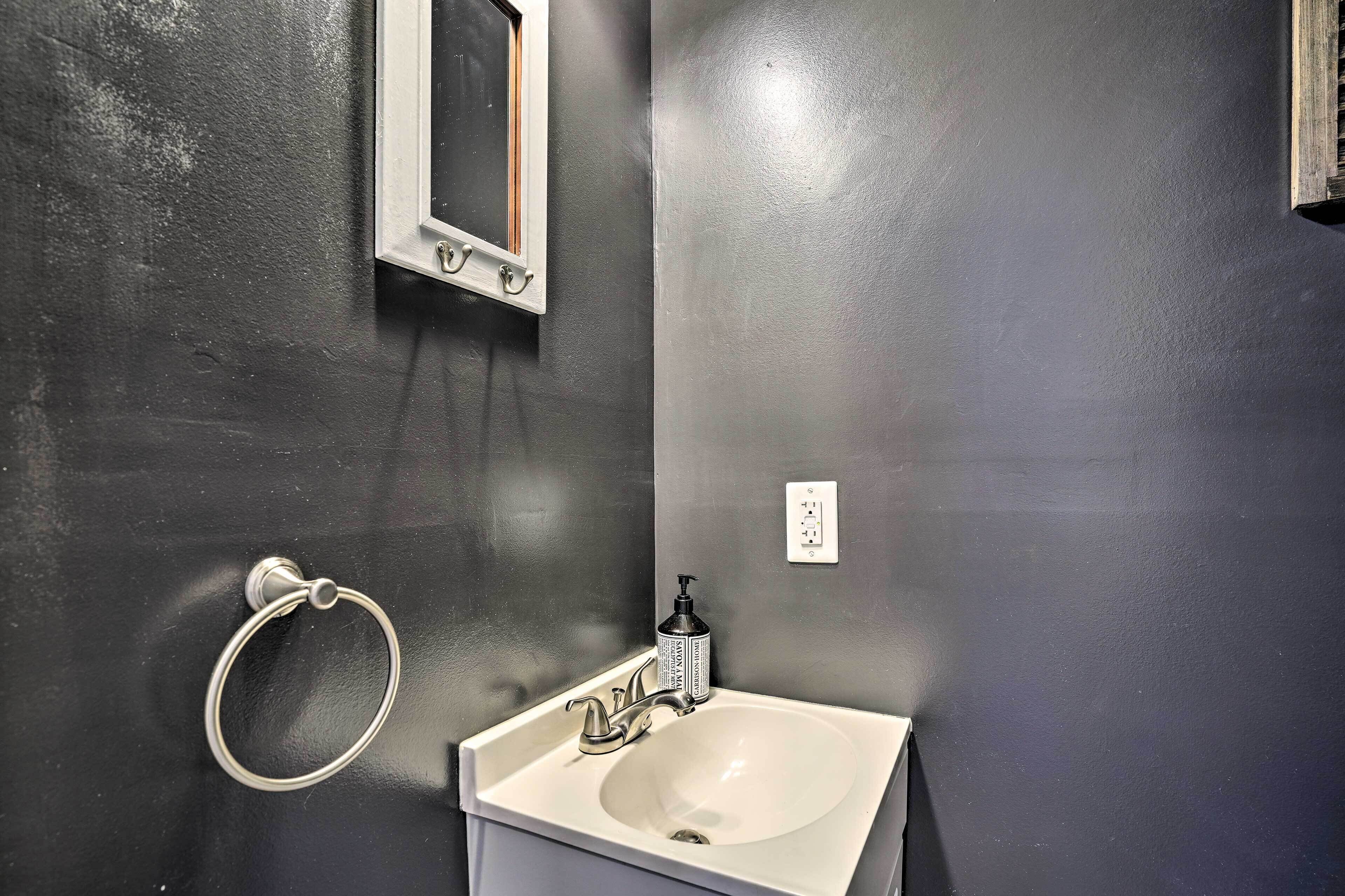 A bathroom with a white sink, a mirror, and a towel ring.