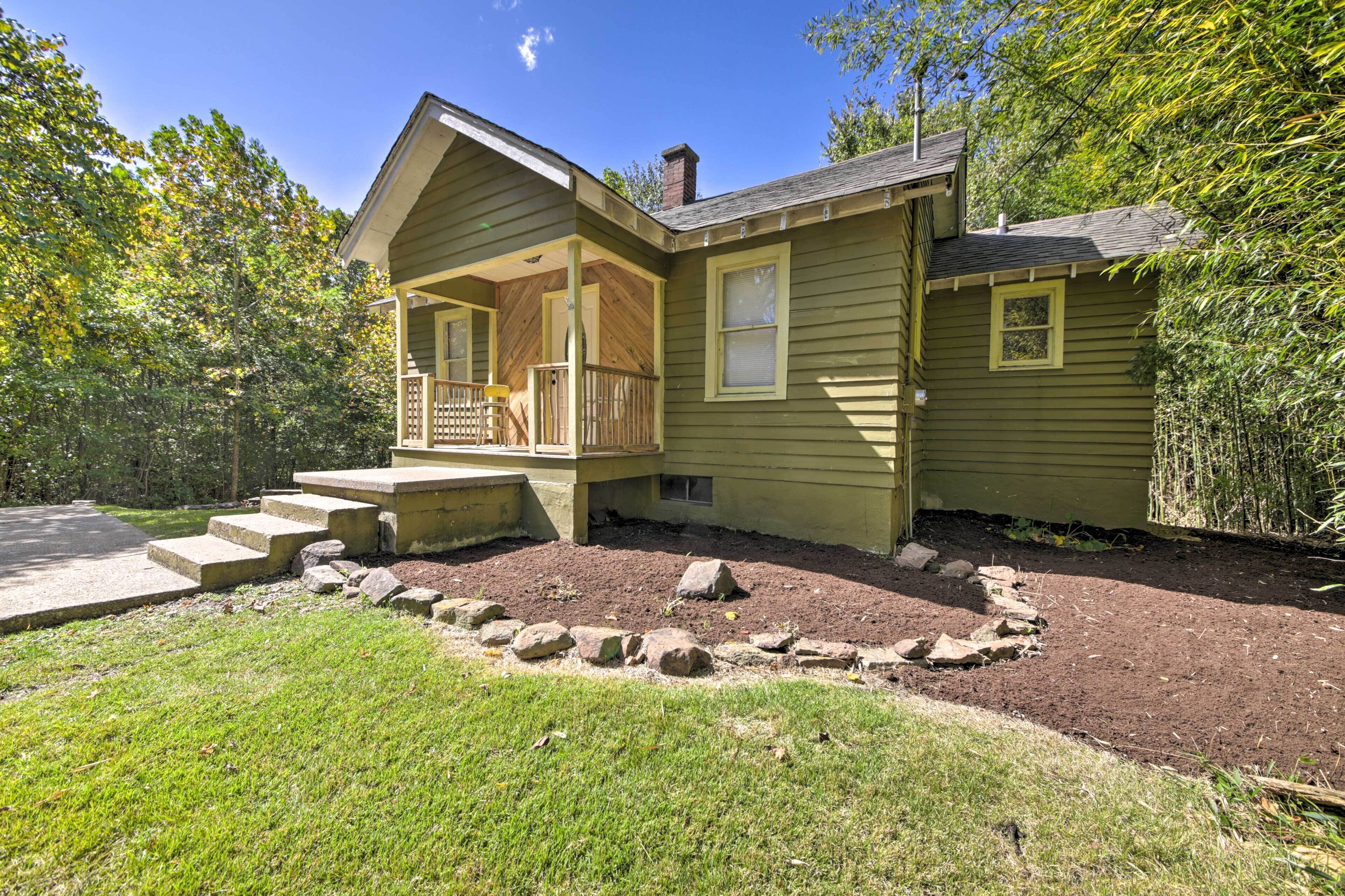 A single-story house with a porch, a chimney, and a small garden area with stepping stones.
