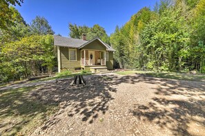 A two-story house with a porch, surrounded by trees and a gravel driveway. - Pet-friendly Cottage w/ Fire Pit - 3 Mi to Siu! (Carbondale)