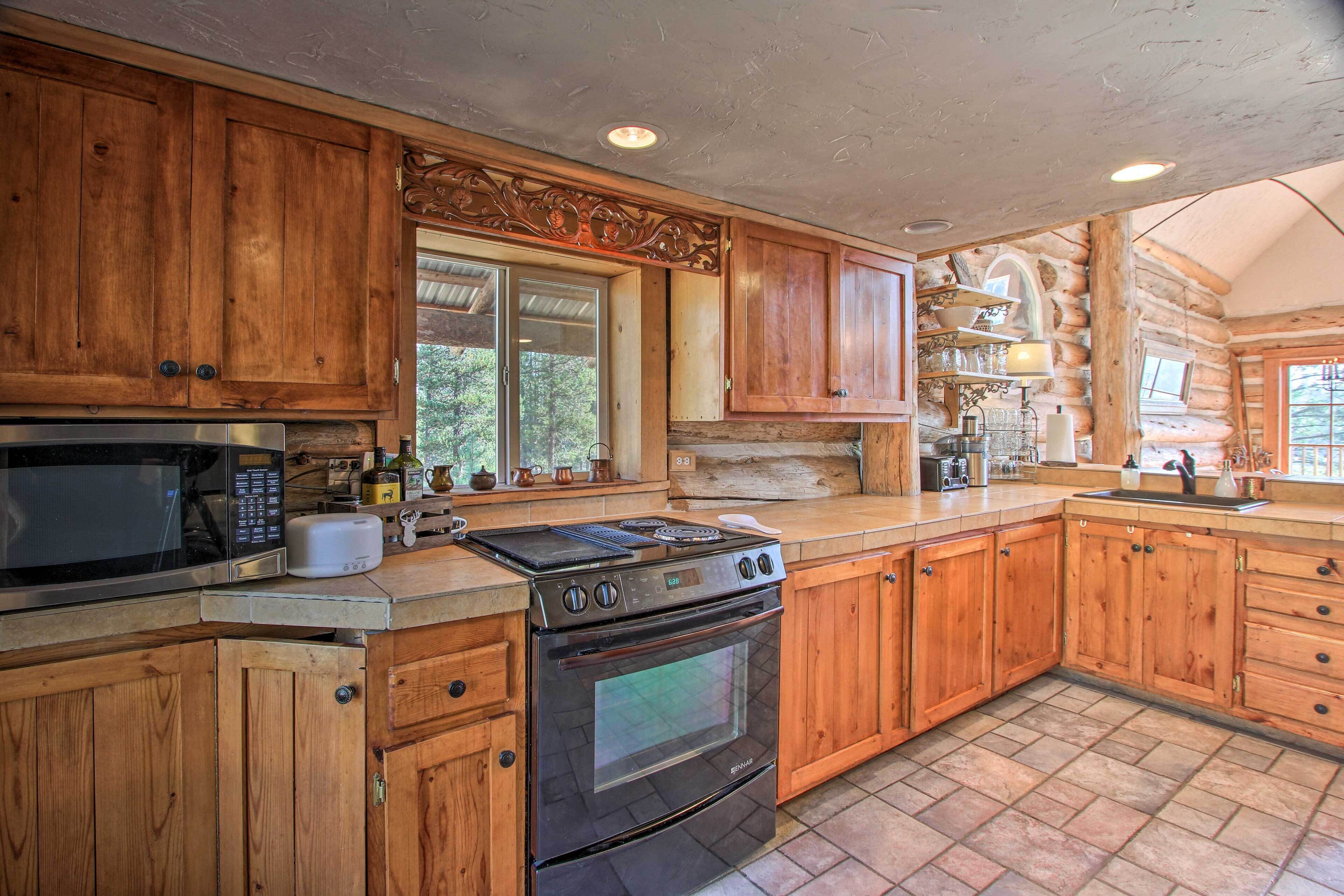 A kitchen with wooden cabinets, a microwave, a stove, and a sink.