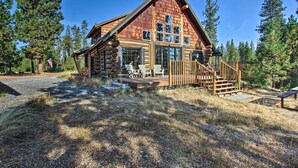 A log cabin with a deck, large windows, and a flag. - Snow Pine Retreat - Remote Crescent Log Cabin! (Crescent)