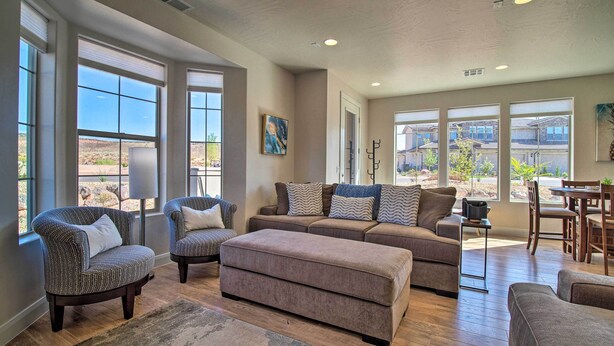 A spacious living room with large windows, a sofa set, and a dining area. - Modern Washington Home - Pool & Trail Access! (Washington)