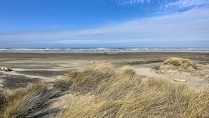 A beach with sand dunes and the ocean in the background. - Sanderling Sea Cottages, Unit 14 (Waldport)