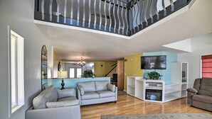 A spacious living area with a grey sofa, a coffee table, and a TV on a white stand. - Sun-soaked Coastal Cottage w/ Deck + Walk to Beach (Old Orchard Beach)