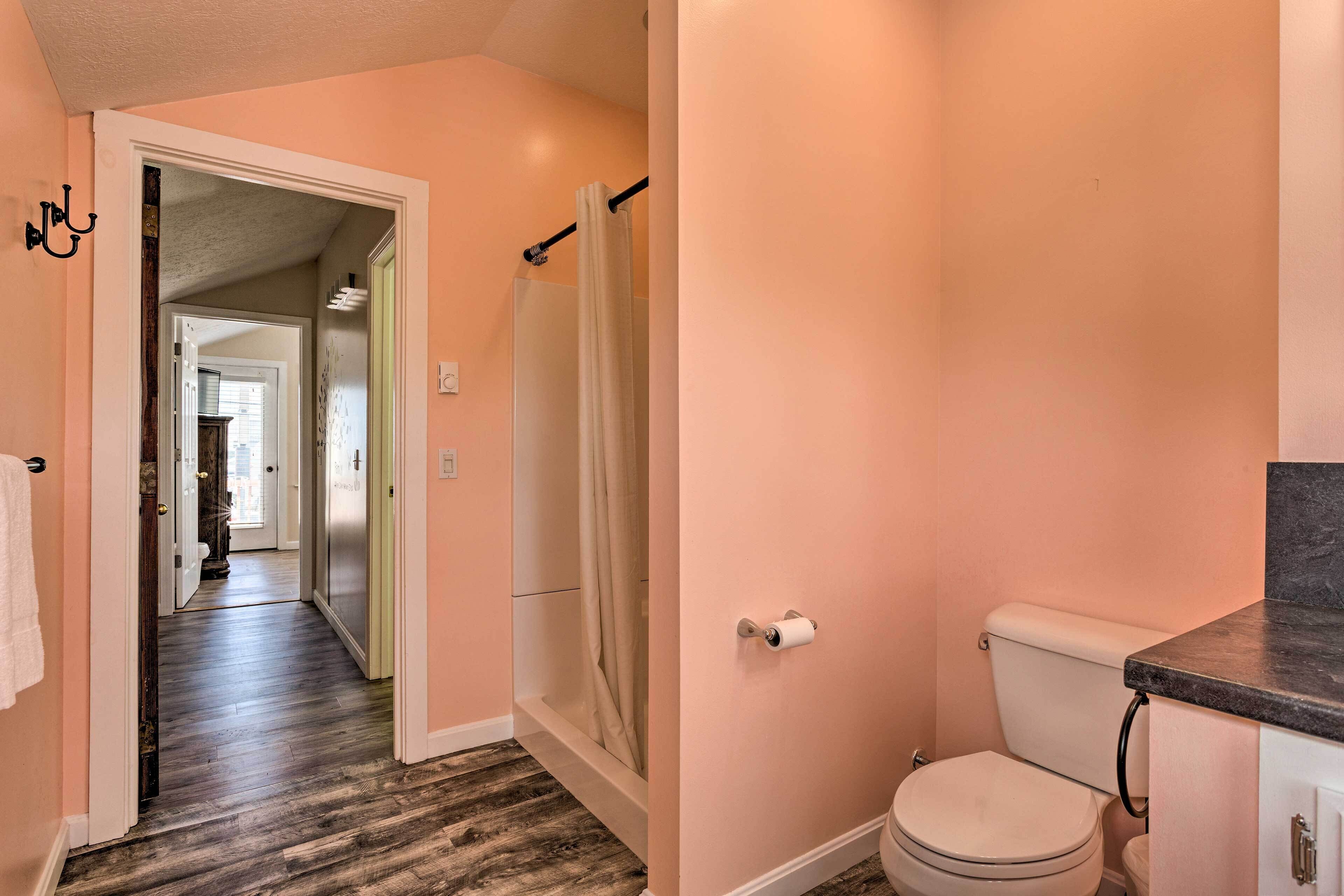 A bathroom with a toilet, shower curtain, and a visible toilet paper holder.