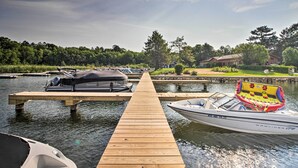 A wooden dock extending into calm water with boats moored at the end. - Walk to Gull Lake! Spacious Family Home w/ Deck (Nisswa)