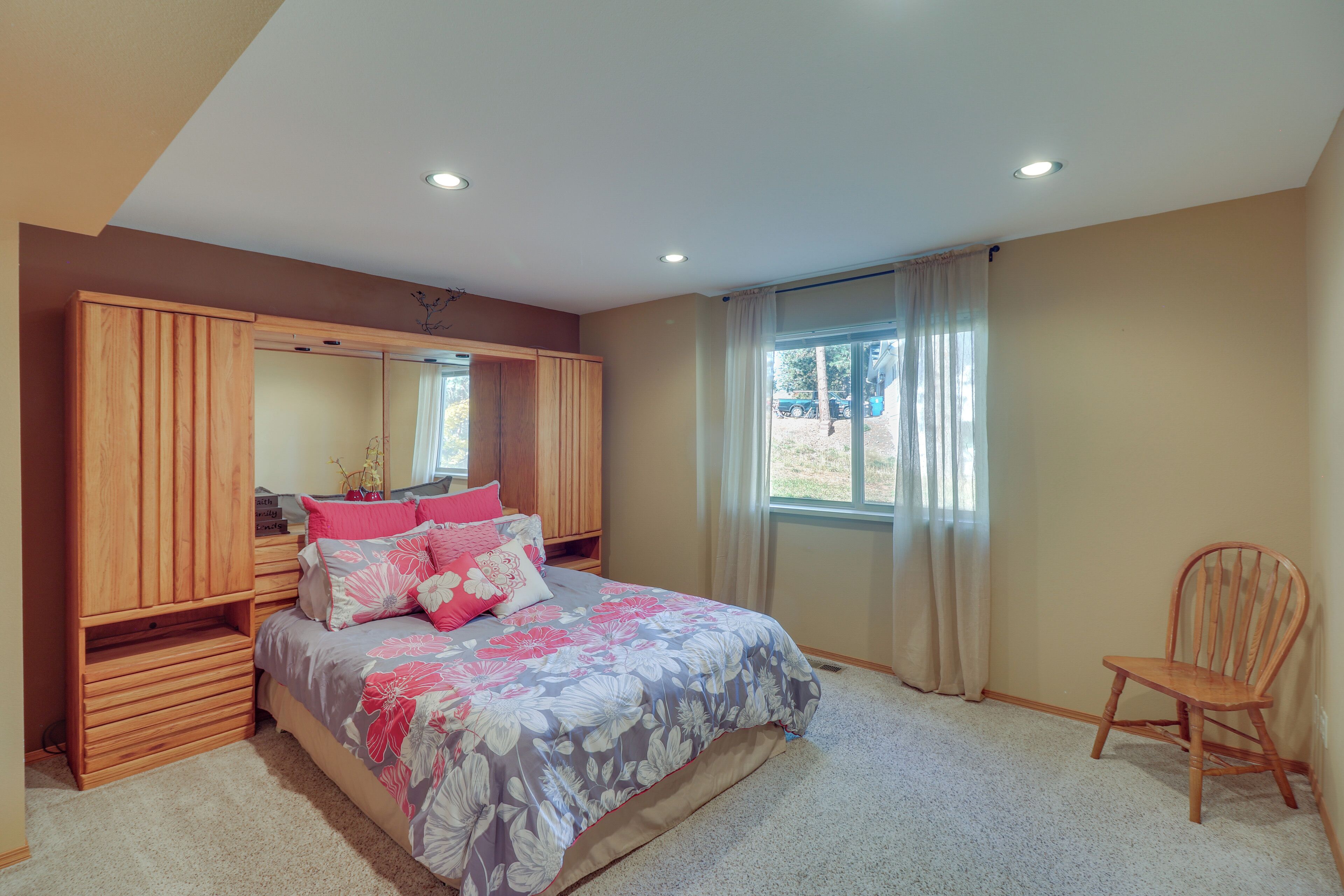 Une chambre à coucher avec un lit, une armoire en bois et une chaise.