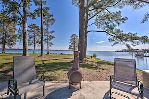 Two chairs facing a large decorative urn on a concrete path with a lake and trees in the background. - Riverfront New Bern House: Gourmet Kitchen & View! (New Bern)