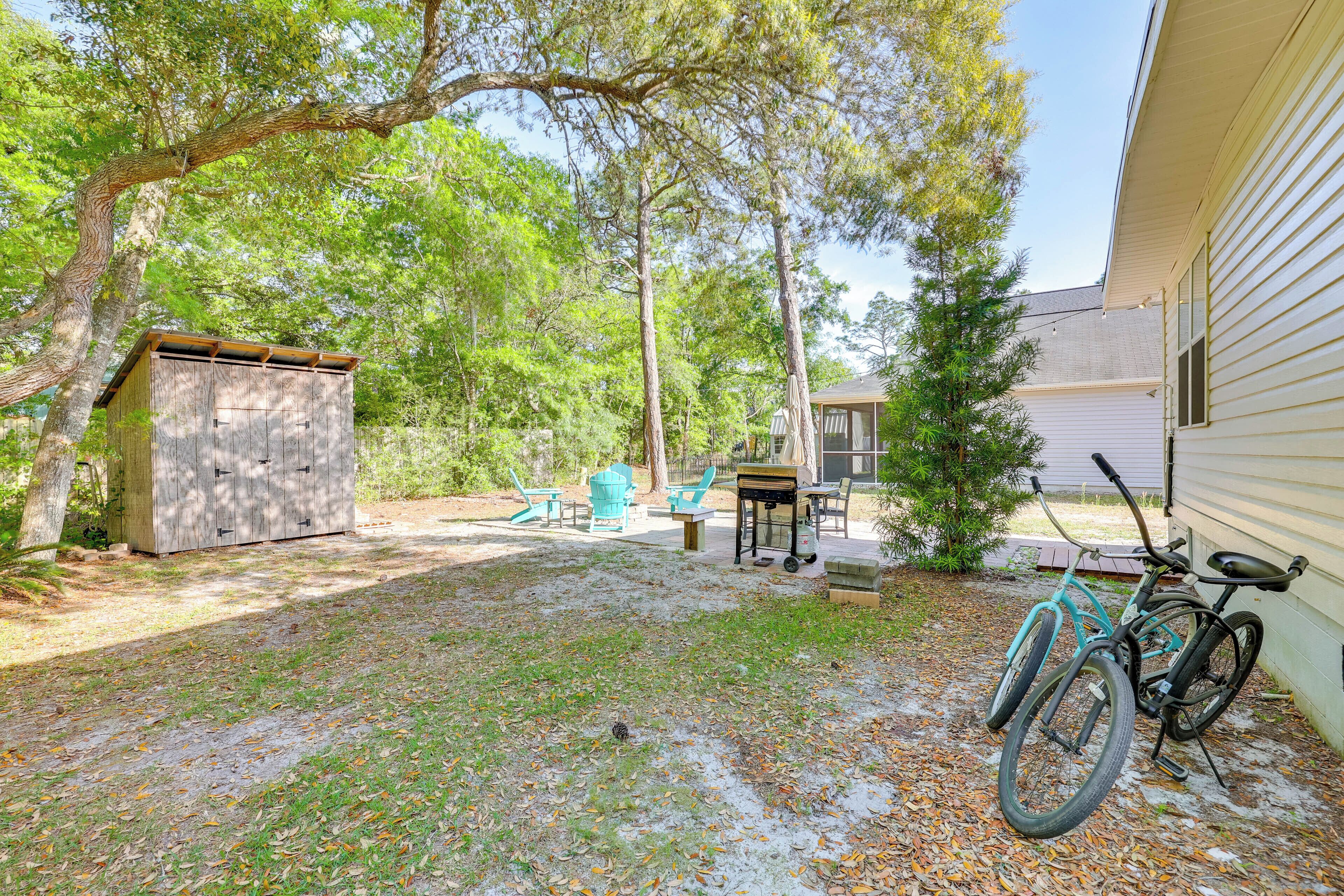 A backyard with a shed, a grill, and a bicycle.