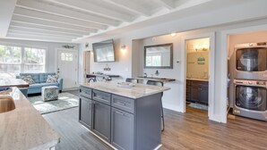 Une cuisine moderne dotée d’un îlot central, de meubles de couleur grise et d’un four encastré.