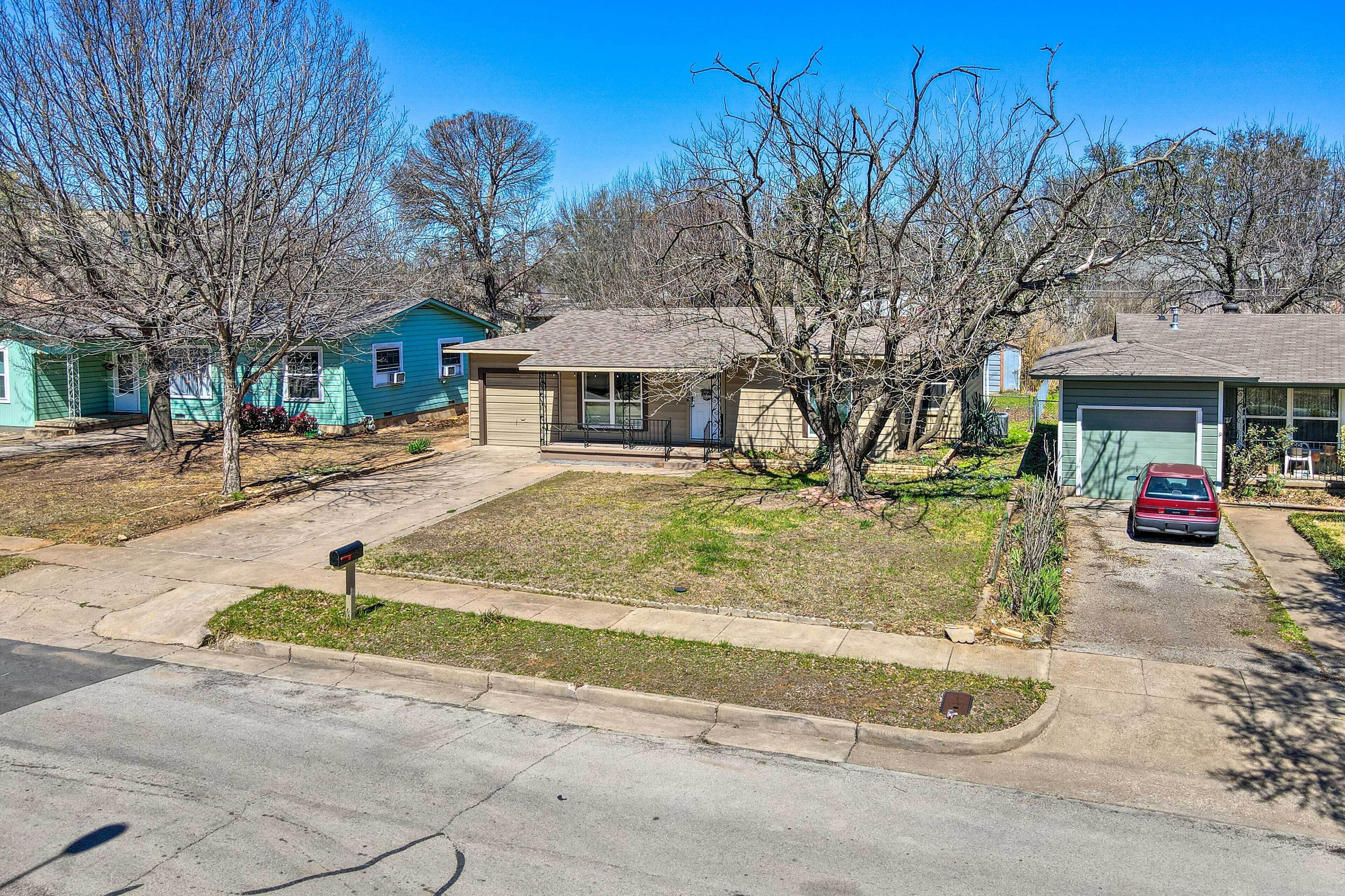 A residential neighborhood with houses, a driveway, and a mailbox.