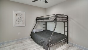 A bunk bed room with a ceiling fan, a framed bird illustration on the wall, and a light-colored wooden floor. - St Petersburg Getaway - 5 Mi to Tropicana Field! (St. Petersburg)