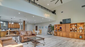 A spacious living area with a high ceiling, a dining area, and a kitchen with wooden cabinets and a stone backsplash. - St Petersburg Getaway - 5 Mi to Tropicana Field! (St. Petersburg)