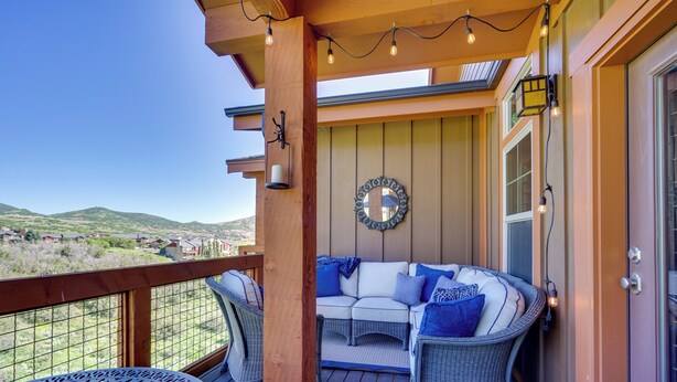 A covered outdoor seating area with wicker furniture, a wooden deck, and a view of the landscape. - Mountain-view Condo ~ 9 Mi to Park City Skiing (Heber City)