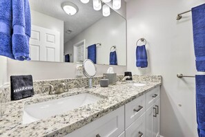 A bathroom with two sinks, a mirror, and a towel rack with multiple towels. - Charming Southern Pines Abode - Walk to Dtwn! (Southern Pines)