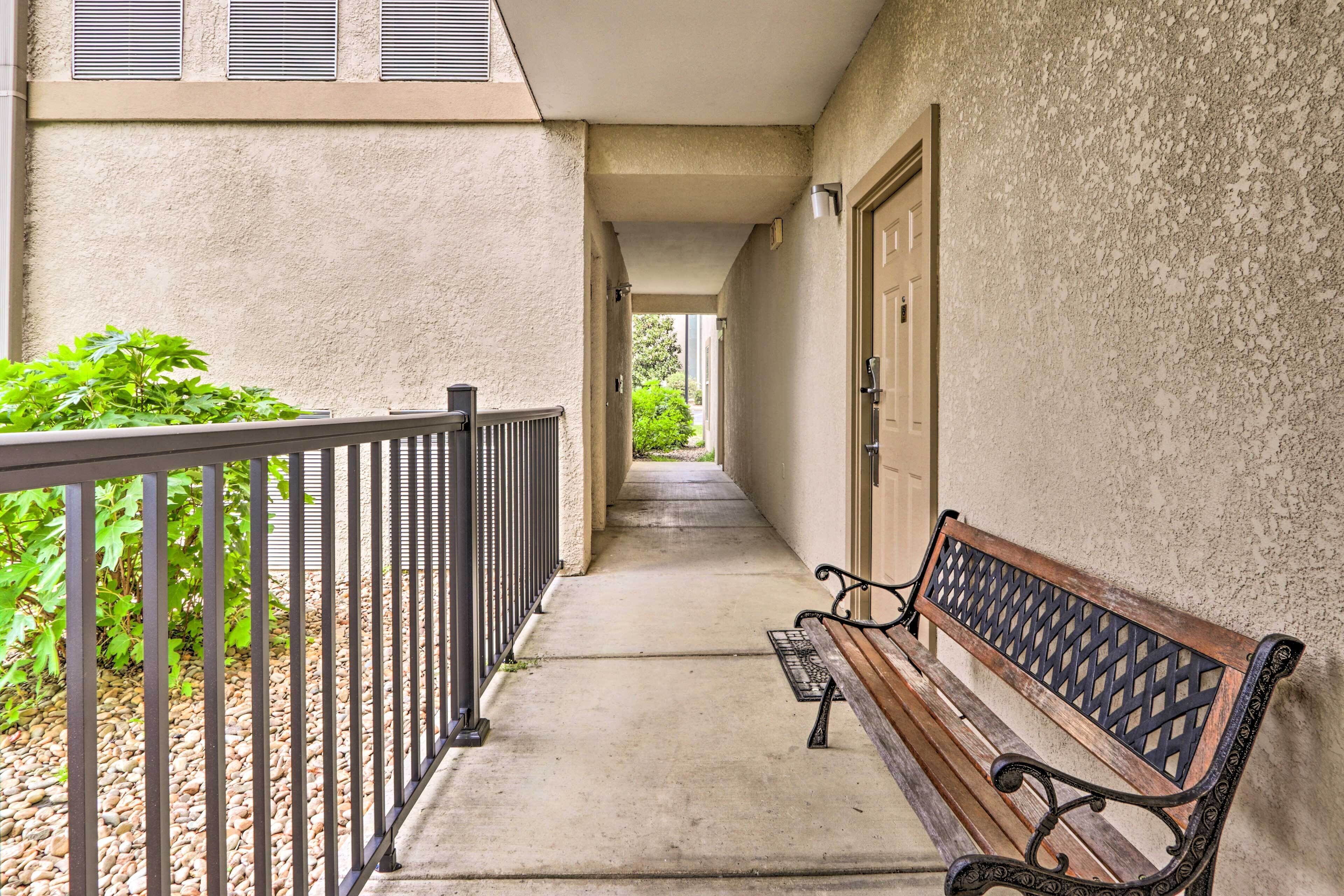A narrow corridor with a bench and a door on the right.