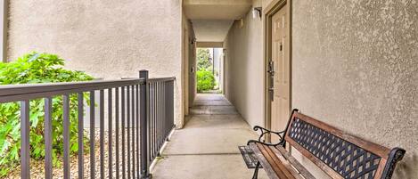 A narrow corridor with a bench and a door on the right.