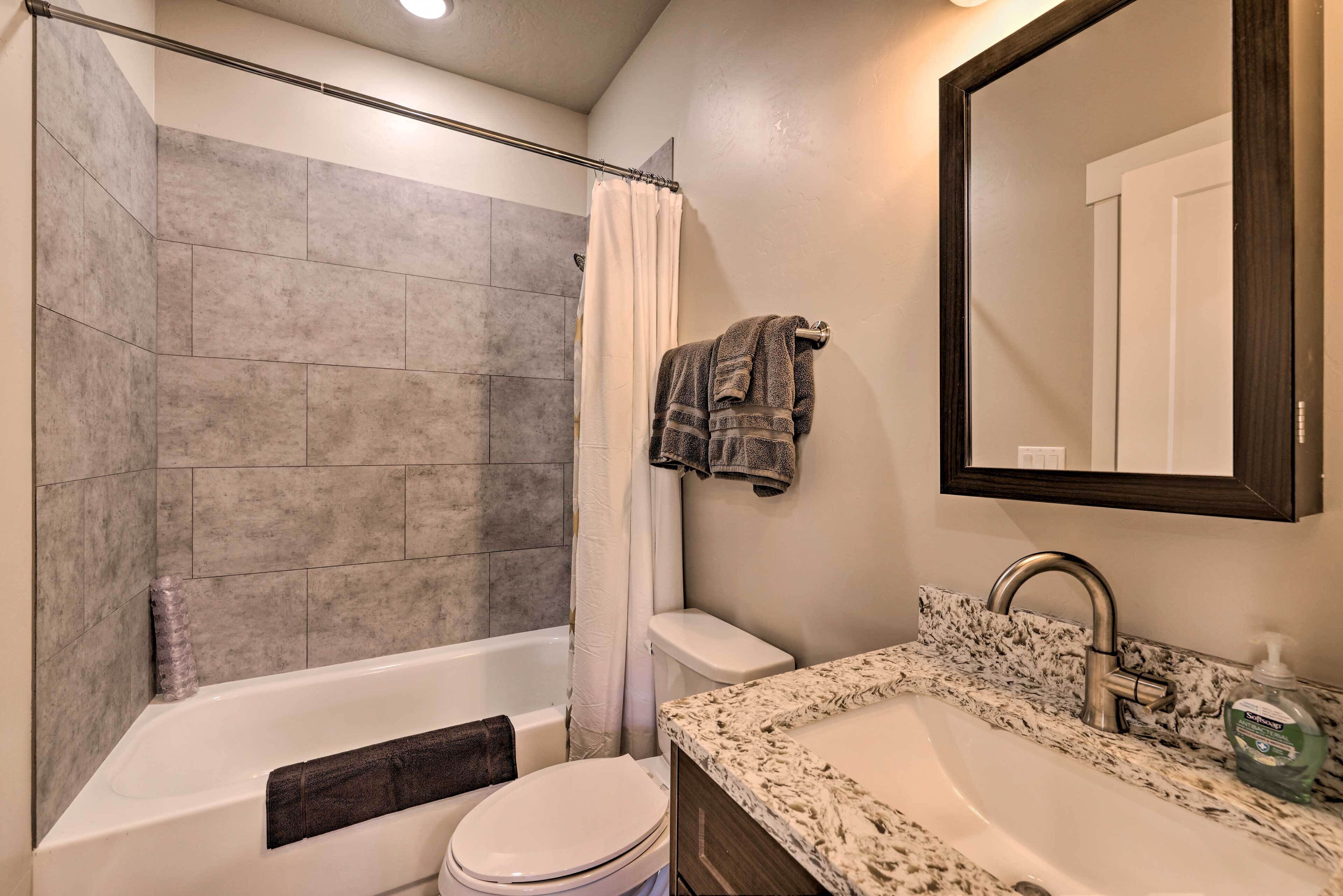 A bathroom with a bathtub, toilet, and sink.