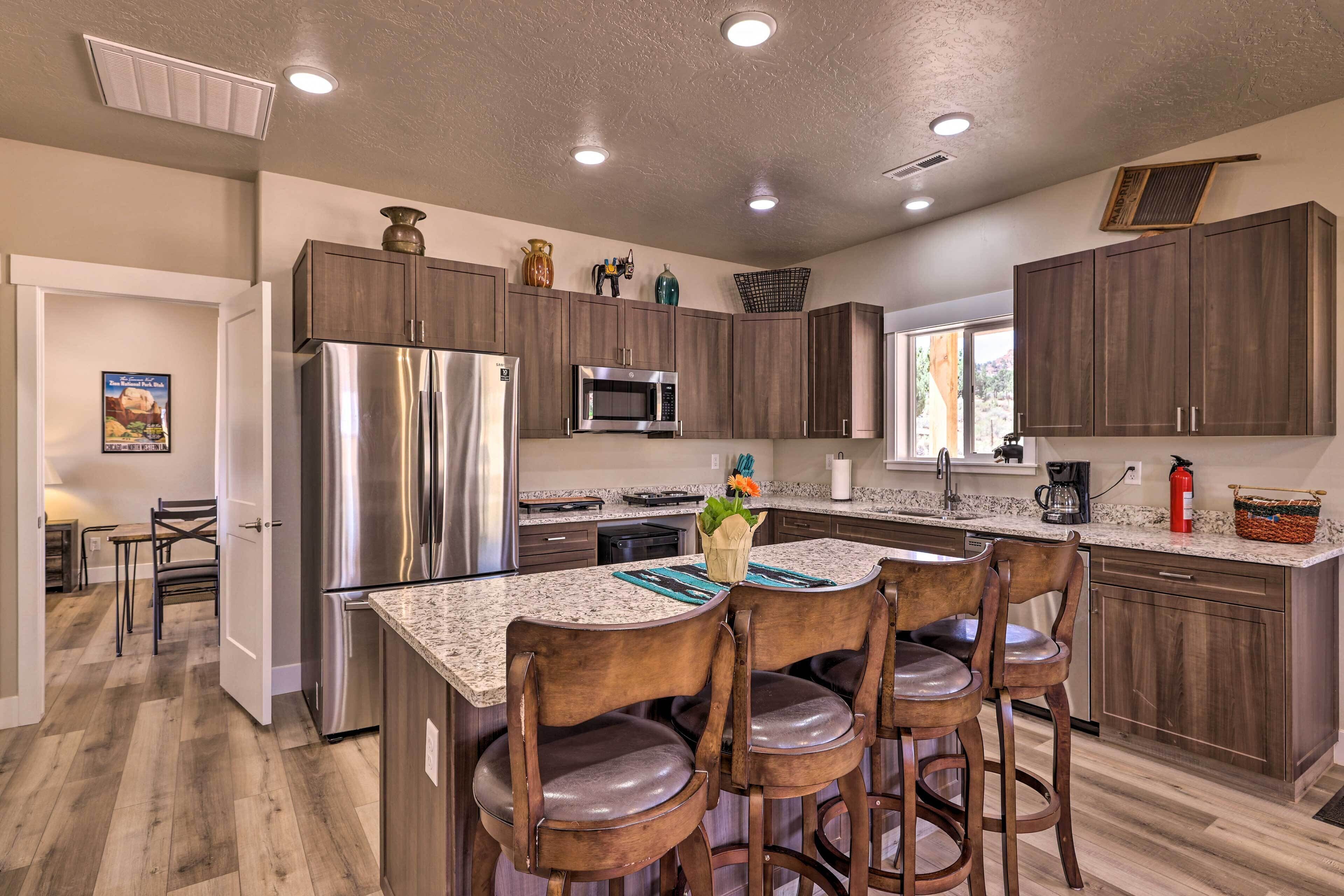 A modern kitchen with dark wood cabinets, stainless steel appliances, and a granite countertop.