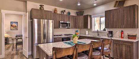 A modern kitchen with dark wood cabinets, stainless steel appliances, and a granite countertop.