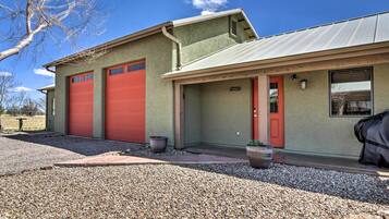 A building with two red garage doors, a red door, and a window.