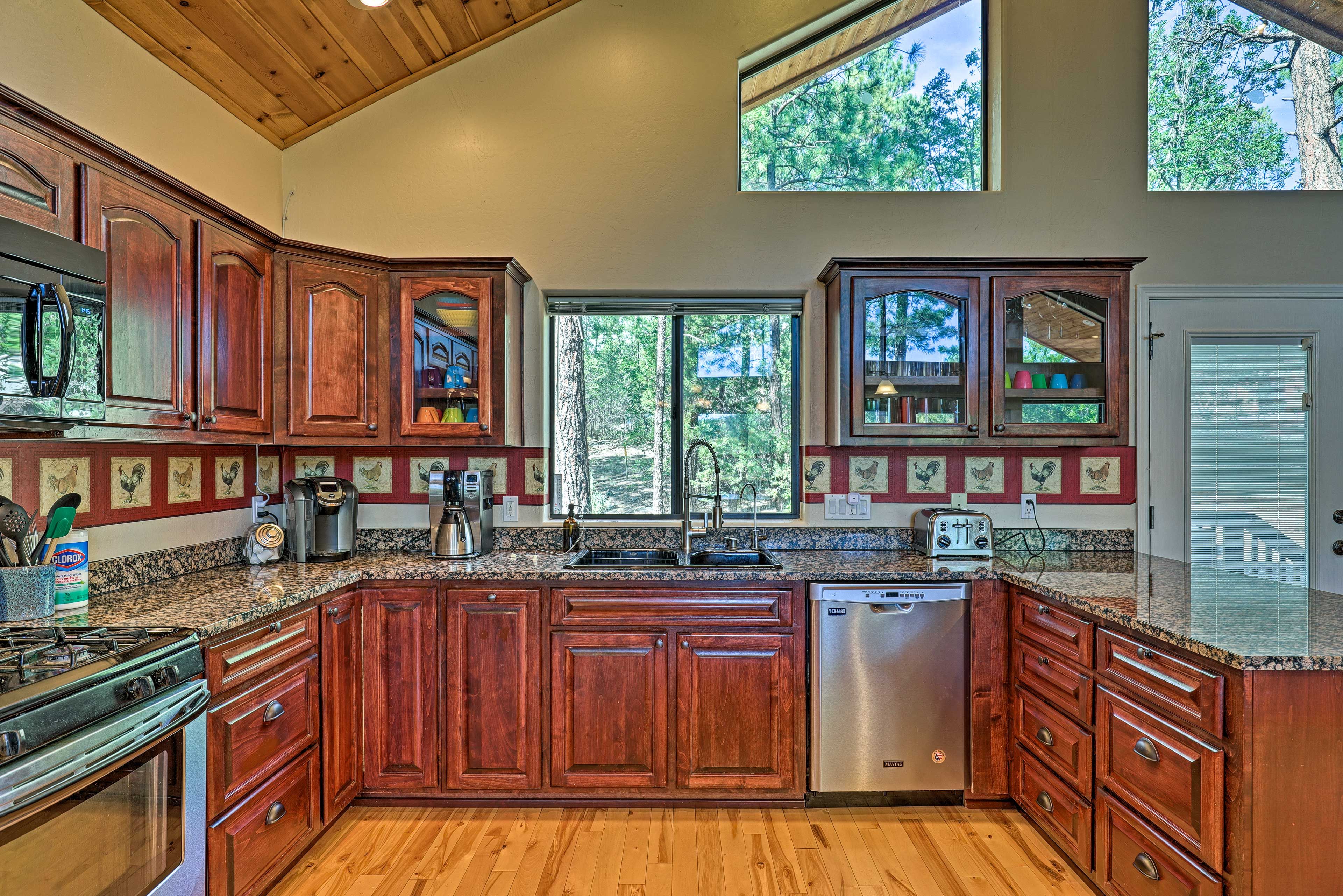 A kitchen with wooden cabinets, a stainless steel dishwasher, and a granite countertop.