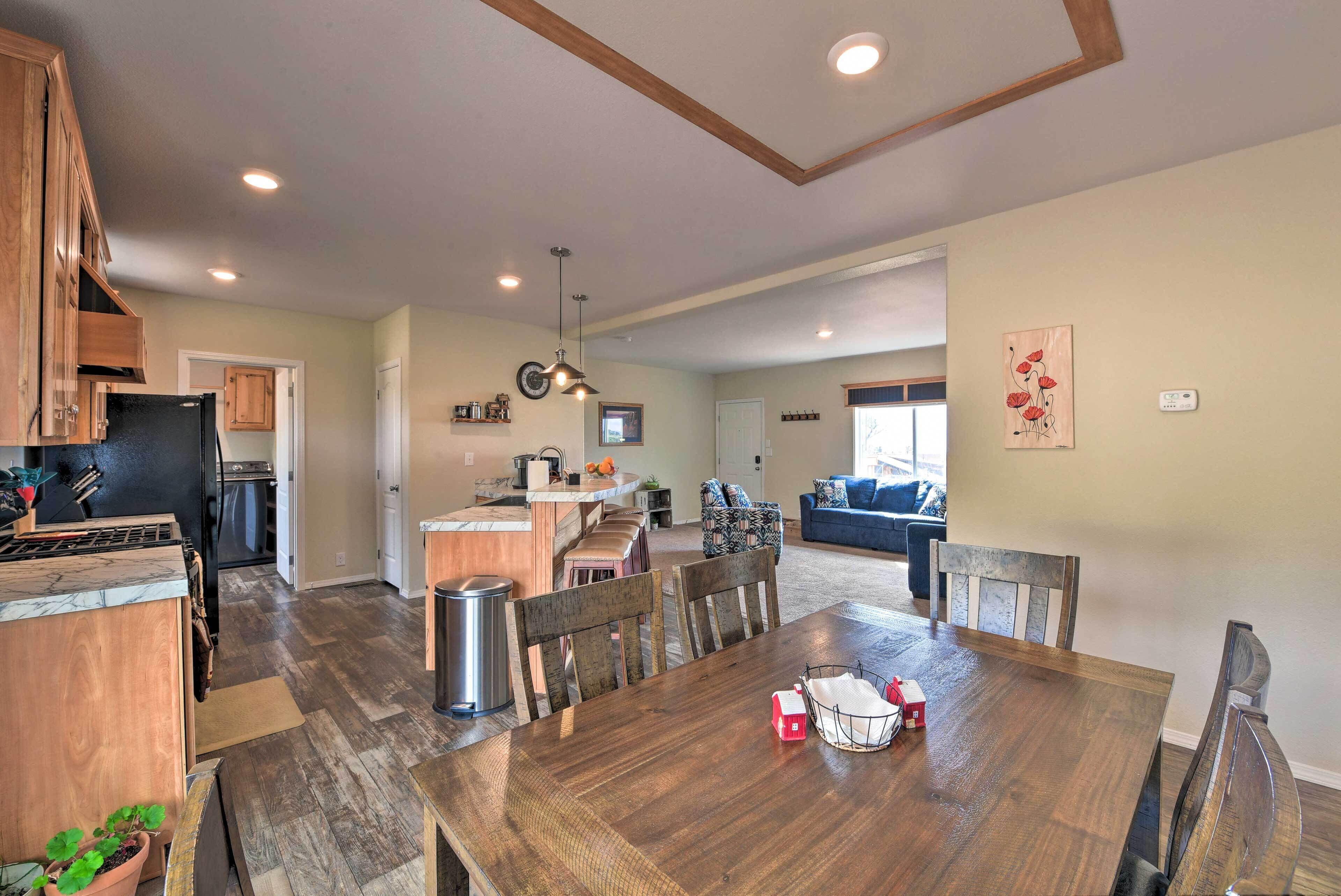 A spacious kitchen with wooden cabinets, a dining table, and a bar area.