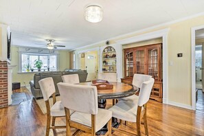 A dining area with a round table and six chairs, a ceiling fan, and a brick wall. - Family Getaway Near Delaware River & Intl Soccer! (Gibbstown)