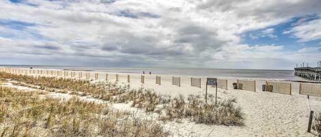 A sandy beach with a wooden fence and a sign indicating a protected area.