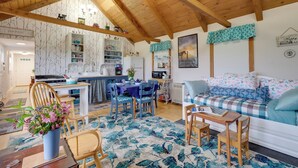 Un interior de cabaña acogedor con comedor, cocina y sala de estar.