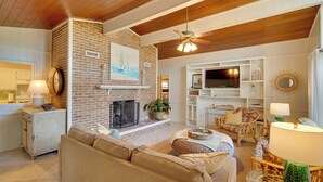 Un salon chaleureux avec une cheminée, des fauteuils confortables et un téléviseur.